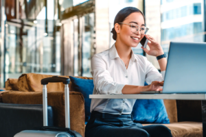 Woman with laptop and phone in hotel lobby