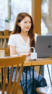 Frau nutzt iXCharger am Laptop im Café